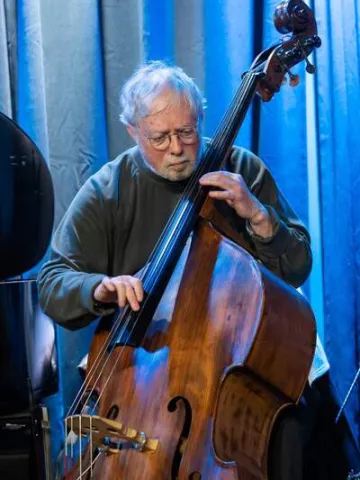 Clyde Playing double bass against a blue curtain