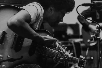 Mustafa Playing Guitar and Holding Bells